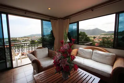 a living room with a couch and chairs on a balcony at Sun Hill Hotel Patong in Patong Beach