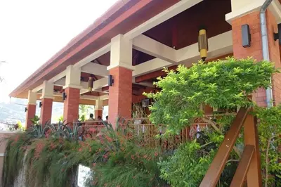 a building with a porch with plants in front of it at Sun Hill Hotel Patong in Patong Beach