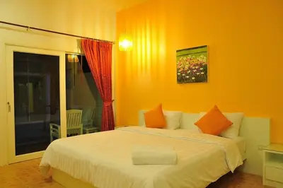 a bedroom with a large bed with orange walls at Clear House Phuket in Kamala Beach