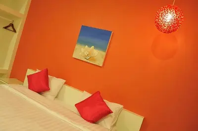 a bedroom with a bed with red pillows at Clear House Phuket in Kamala Beach
