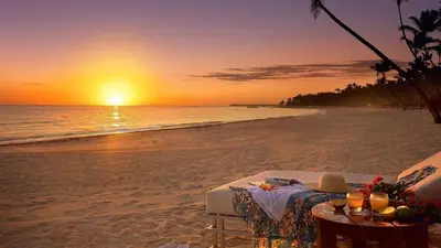 a table on the beach with a sunset in the background at The Shades Hotel 50 meter Beach Front in Patong Beach