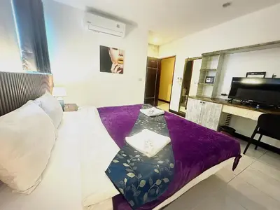 a hotel room with a bed with a purple blanket at The Shades Hotel 50 meter Beach Front in Patong Beach