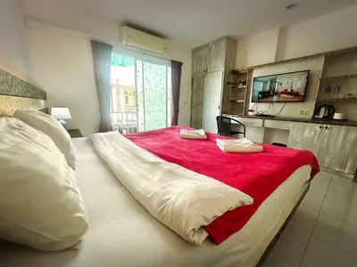 a bedroom with a large bed with a red blanket at The Shades Hotel 50 meter Beach Front in Patong Beach