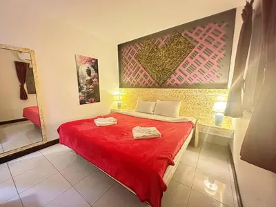 a bedroom with a red bed with two towels on it at The Shades Hotel 50 meter Beach Front in Patong Beach