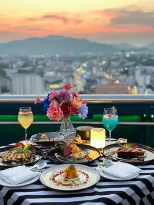 a table with plates of food and glasses of wine at Royal Phuket City Hotel in Phuket Town