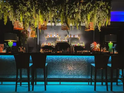 a bar with chairs and a table with drinks at Royal Phuket City Hotel in Phuket Town