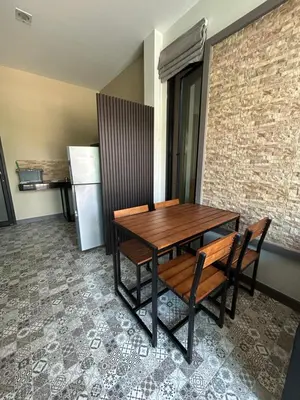 a dining room table with chairs and a refrigerator at Baan Fran Sim Da in Bang Tao Beach