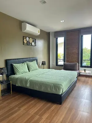 a bedroom with a large bed and two windows at Baan Fran Sim Da in Bang Tao Beach