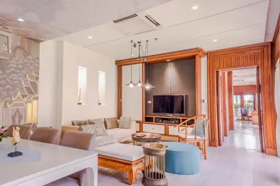 a living room with a couch and a tv at Maikhao Dream Villa Resort and Spa, Maikhao Phuket in Mai Khao Beach
