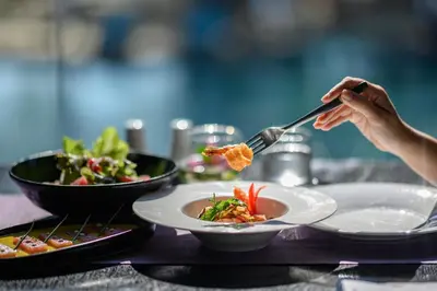 a person eating food on a table with plates of food at Maikhao Dream Villa Resort and Spa, Maikhao Phuket in Mai Khao Beach
