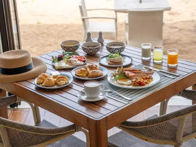 a table with plates of breakfast food on it at Natai Beach Resort in Natai Beach