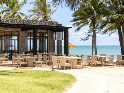 a restaurant on the beach with chairs and palm trees at Natai Beach Resort in Natai Beach