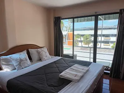 a bedroom with a large bed with towels on it at Patong Rose Guest House 50m to Beach in Patong Beach