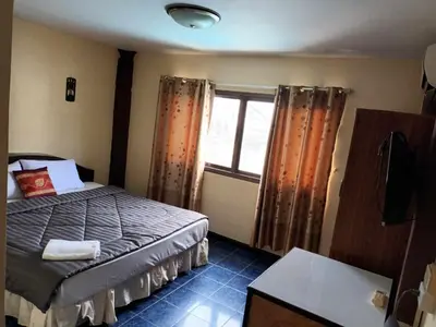 a small bedroom with a bed and a window at Patong Rose Guest House 50m to Beach in Patong Beach