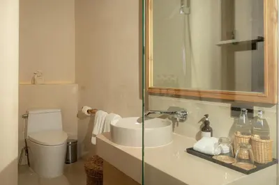 a bathroom with a sink and a toilet and a mirror at Eden Resort & Villas Phuket Patong in Patong Beach
