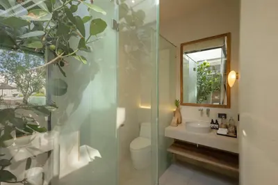 a bathroom with a toilet and a sink and a mirror at Eden Resort & Villas Phuket Patong in Patong Beach