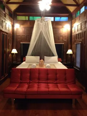 a red couch in a room with a bed at Sea Pines & Liberg in Nai Yang Beach