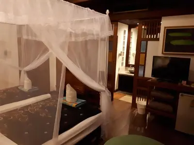 a bedroom with a bed with a white canopy at Sea Pines & Liberg in Nai Yang Beach