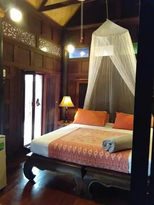 a bedroom with a bed with a mosquito net at Sea Pines & Liberg in Nai Yang Beach