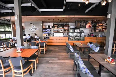 a dining room with wooden tables and chairs at Glur Phuket Patong Beach in Patong Beach