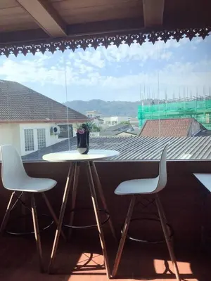 a table and two chairs in front of a window at Baan Ratchapruek in Phuket Town