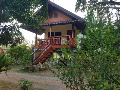 a house with a wooden staircase leading up to it at Mookdaman Bungalow in Ko Yao Noi