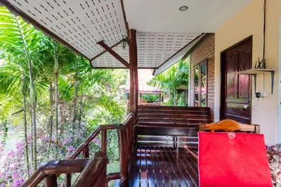 a red bag is sitting on the porch of a house at Mookdaman Bungalow in Ko Yao Noi