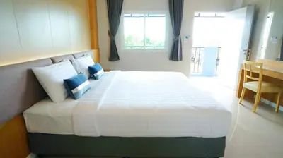 a bedroom with a large white bed with blue pillows at APA-TREE Boutique Hotel in Natai Beach