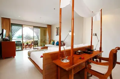 a bedroom with a bed and a desk in a room at Rawai Palm Beach Resort - SHA Extra Plus in Rawai Beach