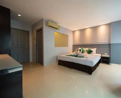 a bedroom with a large bed and a room with at FunDee Boutique Hotel in Patong Beach