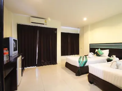 a hotel room with two beds and a flat screen tv at FunDee Boutique Hotel in Patong Beach