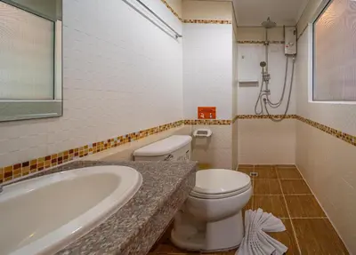 a bathroom with a toilet and a sink and a tub at FunDee Boutique Hotel in Patong Beach