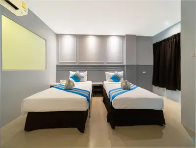 two twin beds in a room with at FunDee Boutique Hotel in Patong Beach