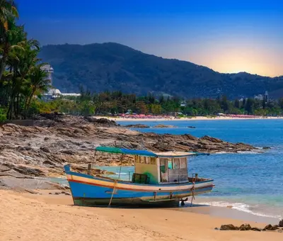 a boat sitting on the sand on a beach at FunDee Boutique Hotel in Patong Beach