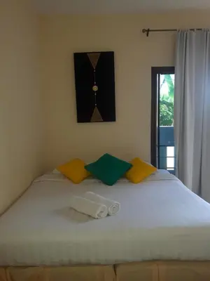 a bed with two pillows and a clock on the wall at Classic home in Bang Tao Beach
