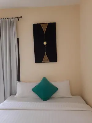 a bed with a clock on the wall above it at Classic home in Bang Tao Beach