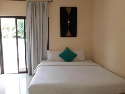 a bedroom with a bed with a clock on the wall at Classic home in Bang Tao Beach
