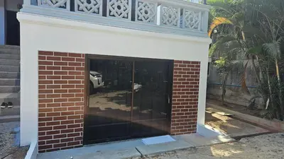 a brick fireplace with a balcony on top of it at Classic home in Bang Tao Beach