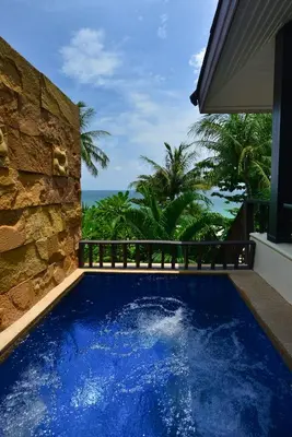 a swimming pool with a view of the ocean at Andaman White Beach Resort - SHA Plus in Nai Thon Beach