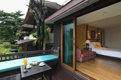 a room with a balcony with a bed and a bedroom at Andaman White Beach Resort - SHA Plus in Nai Thon Beach