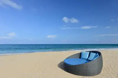 a blue chair sitting on the beach at Andaman White Beach Resort - SHA Plus in Nai Thon Beach
