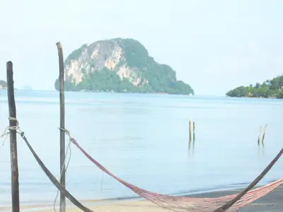 a hammock on the beach with an island in the water at Koh Yao Beach Front in Ko Yao Yai