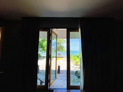 a room with a view of the beach through a window at Koh Yao Beach Front in Ko Yao Yai