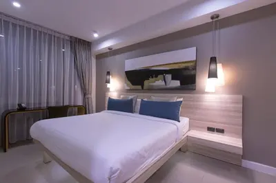 a bedroom with a large white bed with blue pillows at Oceanstone by Holy Cow, 1-BR, next building view in Bang Tao Beach