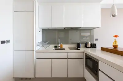 a white kitchen with white cabinets and a sink at Oceanstone by Holy Cow, 1-BR, next building view in Bang Tao Beach