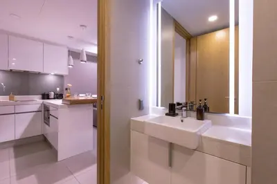 a white kitchen with two sinks and a mirror at Oceanstone by Holy Cow, 1-BR, next building view in Bang Tao Beach