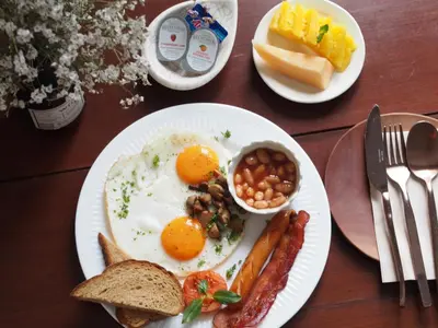 a breakfast plate with eggs sausage beans and toast at Two Villas HOLIDAY - ONYX Style Naiharn Beach, Phuket in Nai Harn Beach