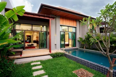 a house with a swimming pool in front of it at Two Villas HOLIDAY - ONYX Style Naiharn Beach, Phuket in Nai Harn Beach