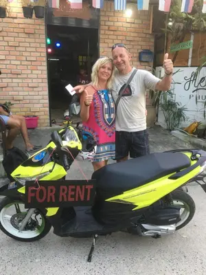 a man and a woman standing next to a motorcycle at Hero Phuket in Nai Yang Beach