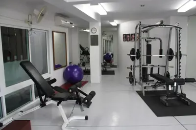 a gym with two treadmills and weights in a room at The Park Surin Serviced Apartments by RESAVA in Surin Beach
